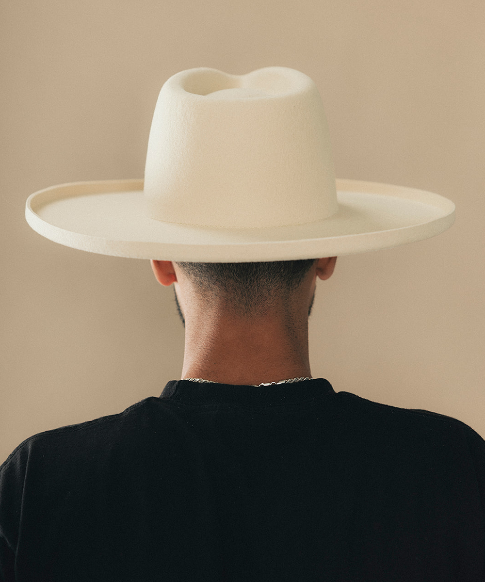 Man wearing a felt wide-brimmed hat with a beige background #color_buckskin