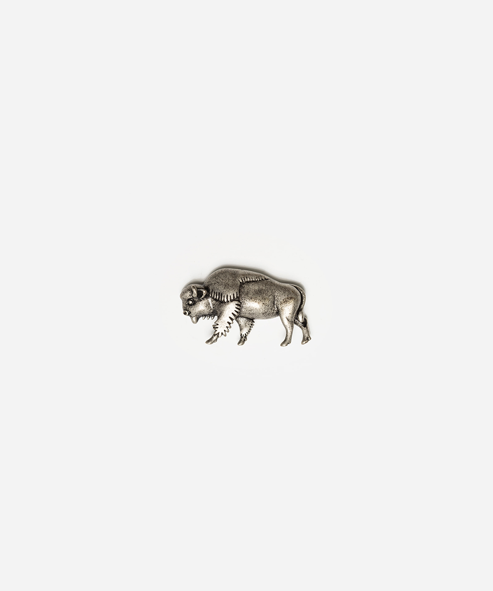 A small metallic bison figurine or charm in an antiqued silver finish, centered on a plain light gray background #color_anti silver
