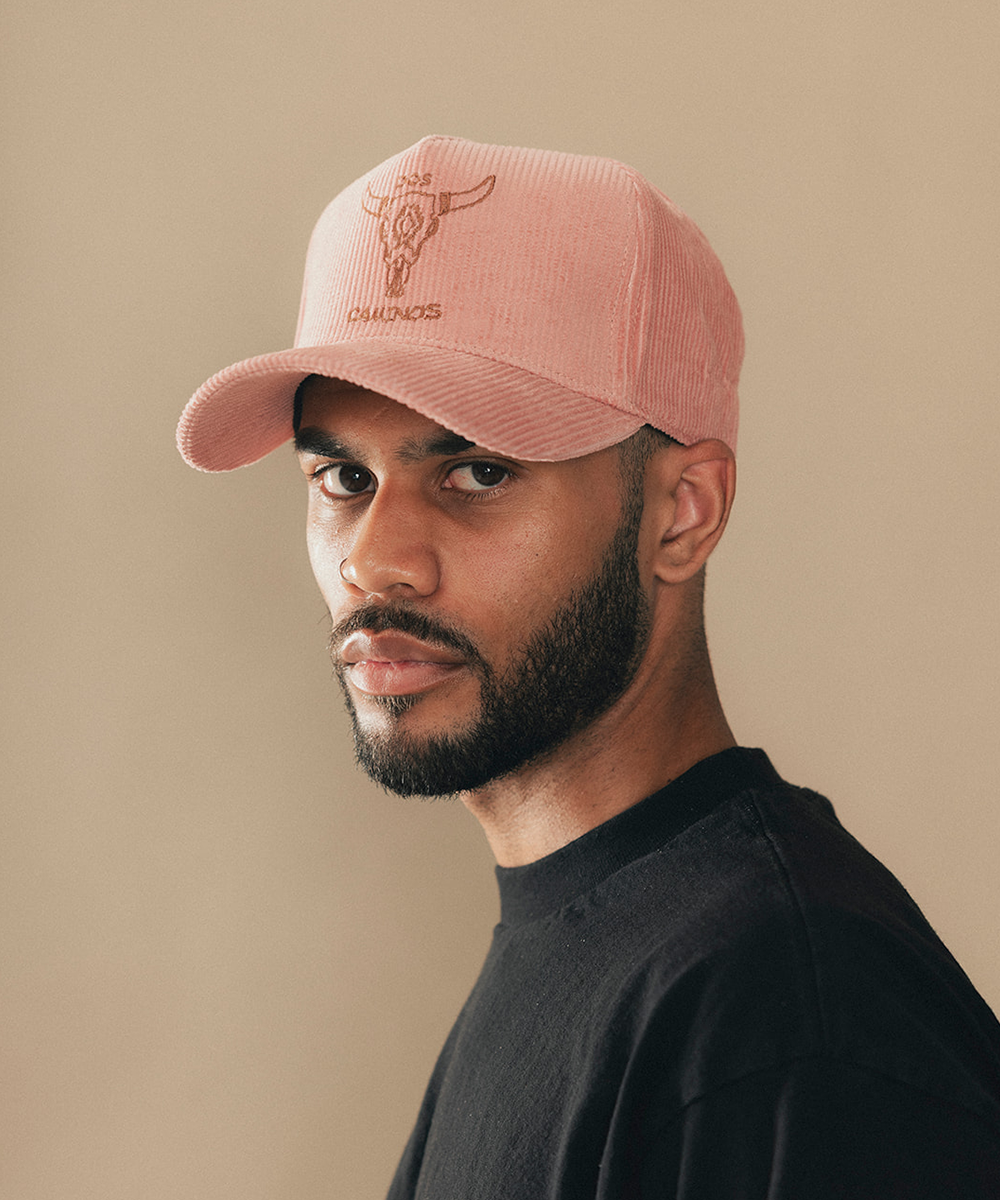 Man wearing a trucker hat in a beige background #color_desert rose