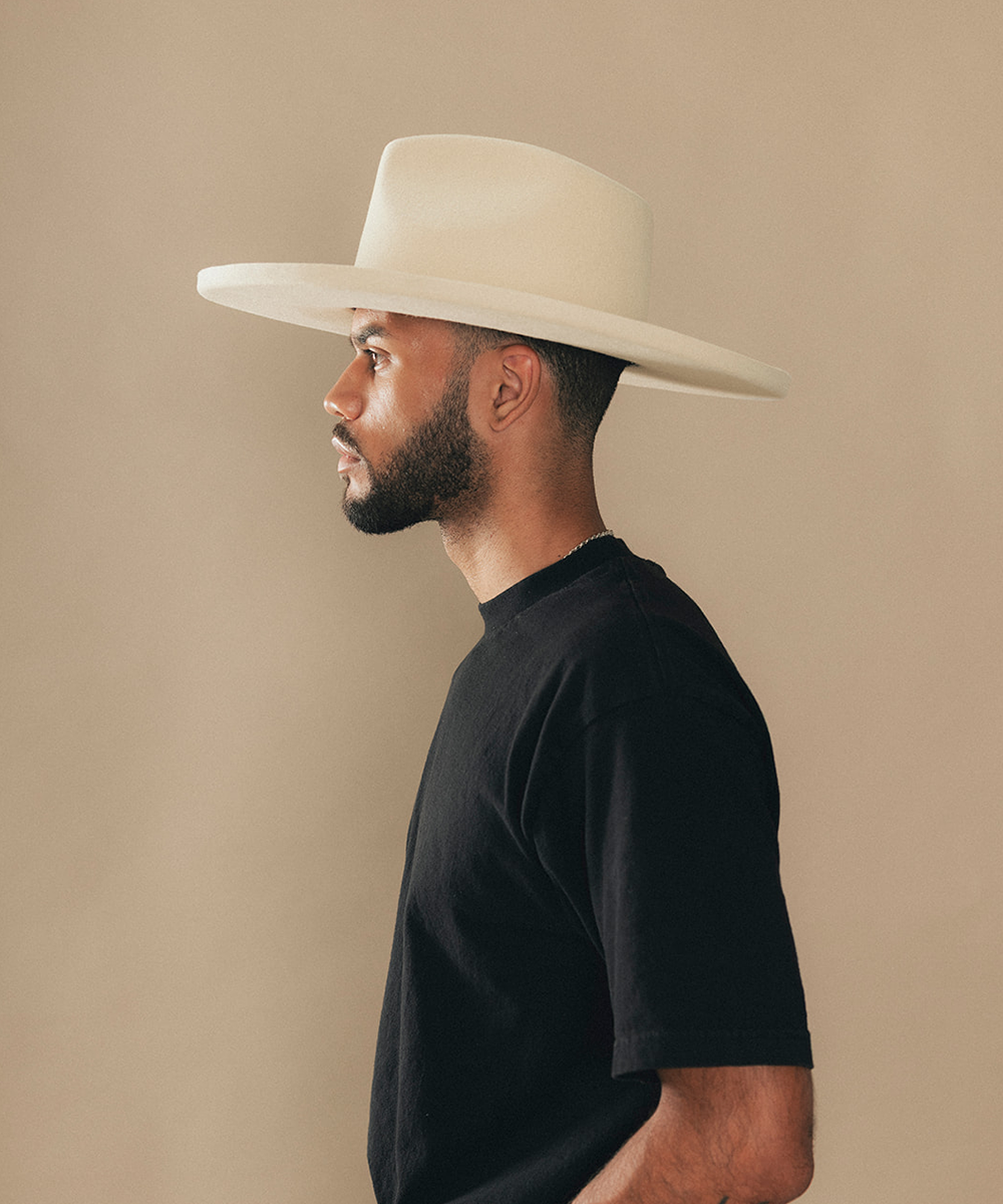 Man wearing a felt wide-brimmed hat with a beige background #color_buckskin