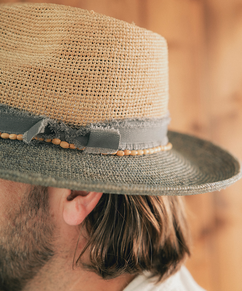 Man wearing a straw hat with a wooden background #color_Natural - Grey Blue