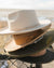 Four Two Roads men's hats for smaller heads stacked atop one another in white, brown, green, and black
