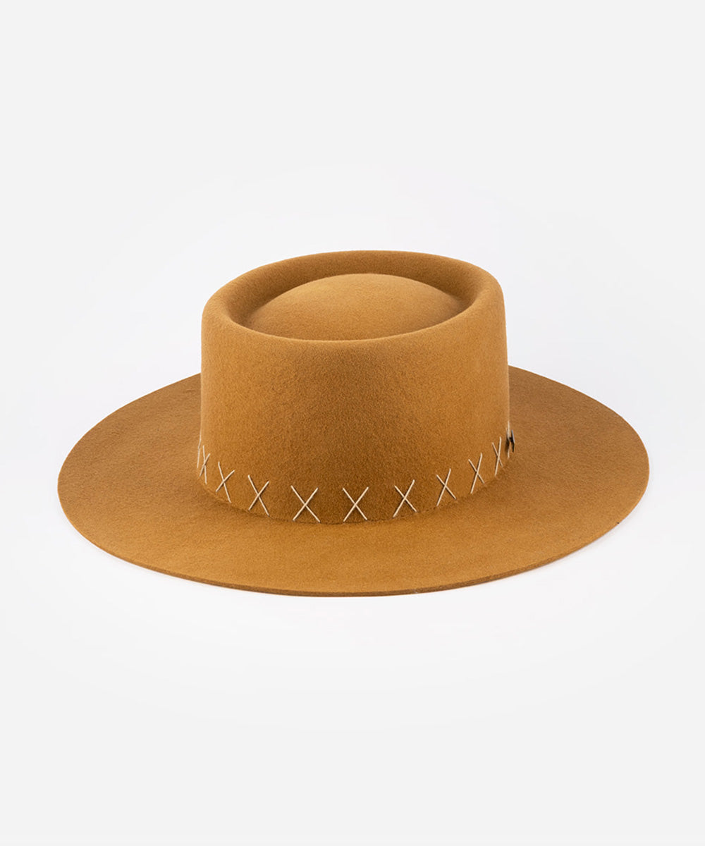 Brown gaucho hat with white stitching on a light gray background #color_rust brown