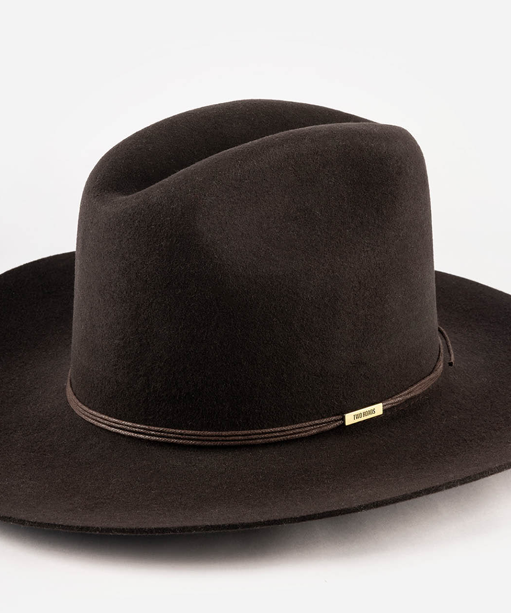 A dark brown felt cowboy hat with a matching brown band and a small gold-tone brand tag, photographed on a clean white background #color_dark brown