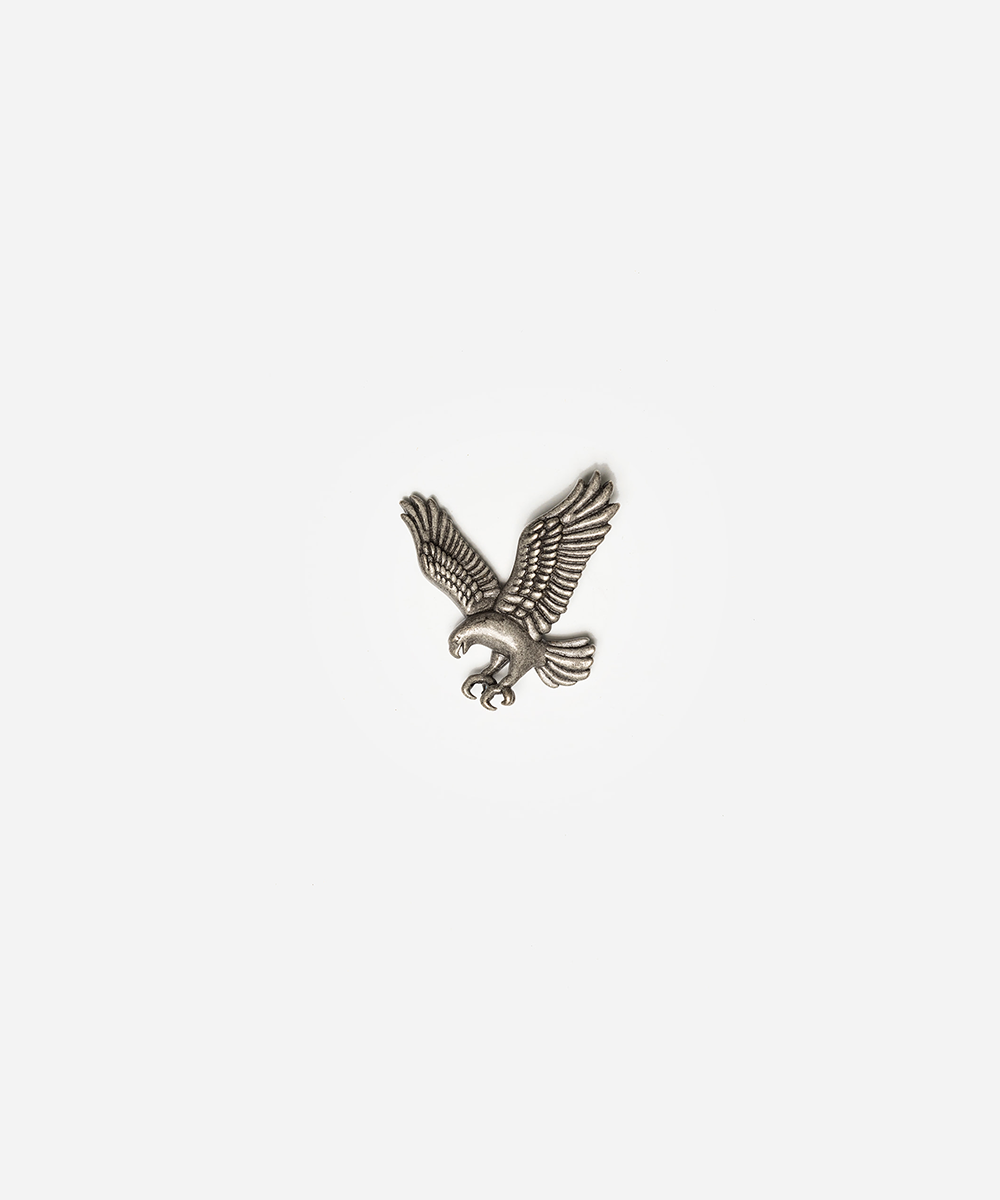 A small silver eagle pendant or charm with outstretched wings, shown centered on a plain light gray background #color_anti silver