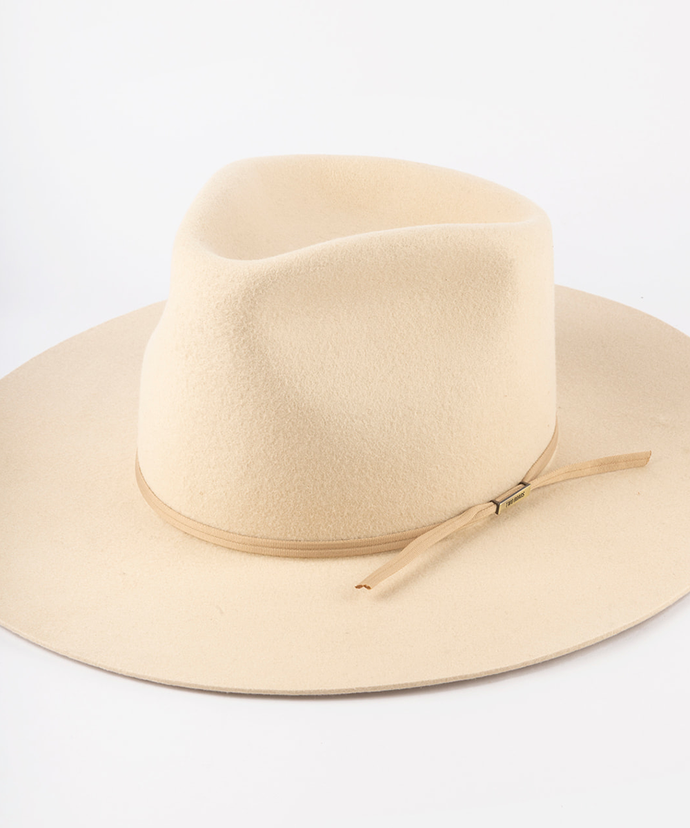 A light beige felt fedora hat with a matching band and a small gold-tone buckle, shown on a clean white background #color_nude