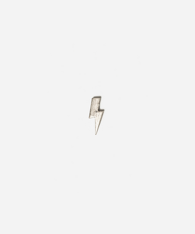 A small silver lightning bolt charm or pendant centered on a plain light gray background #color_anti silver