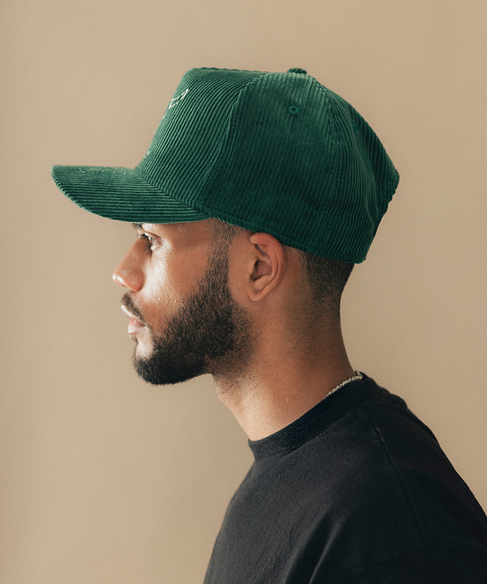 Man wearing a trucker hat in a beige background #color_saguaro