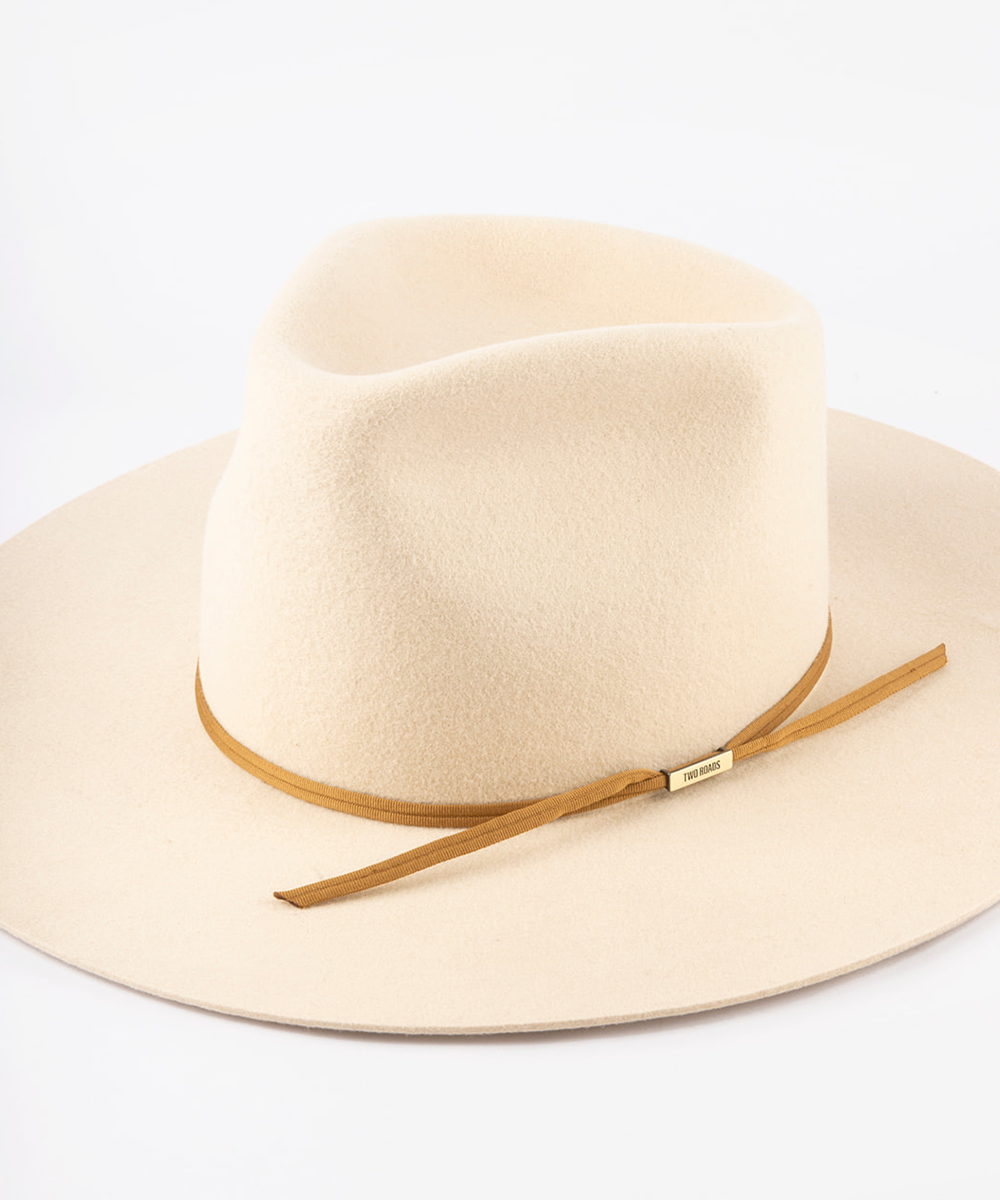 Beige felt fedora hat with a band in a white background #color_brown