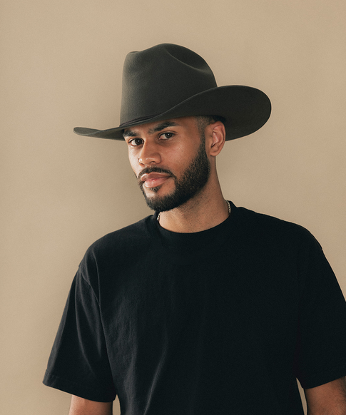Man wearing a cowboy hat with a beige background #color_hickory
