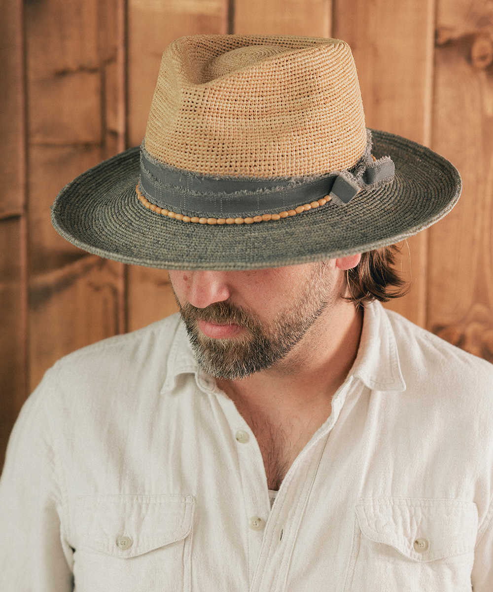Man wearing a straw hat with a wooden background #color_Natural - Grey Blue