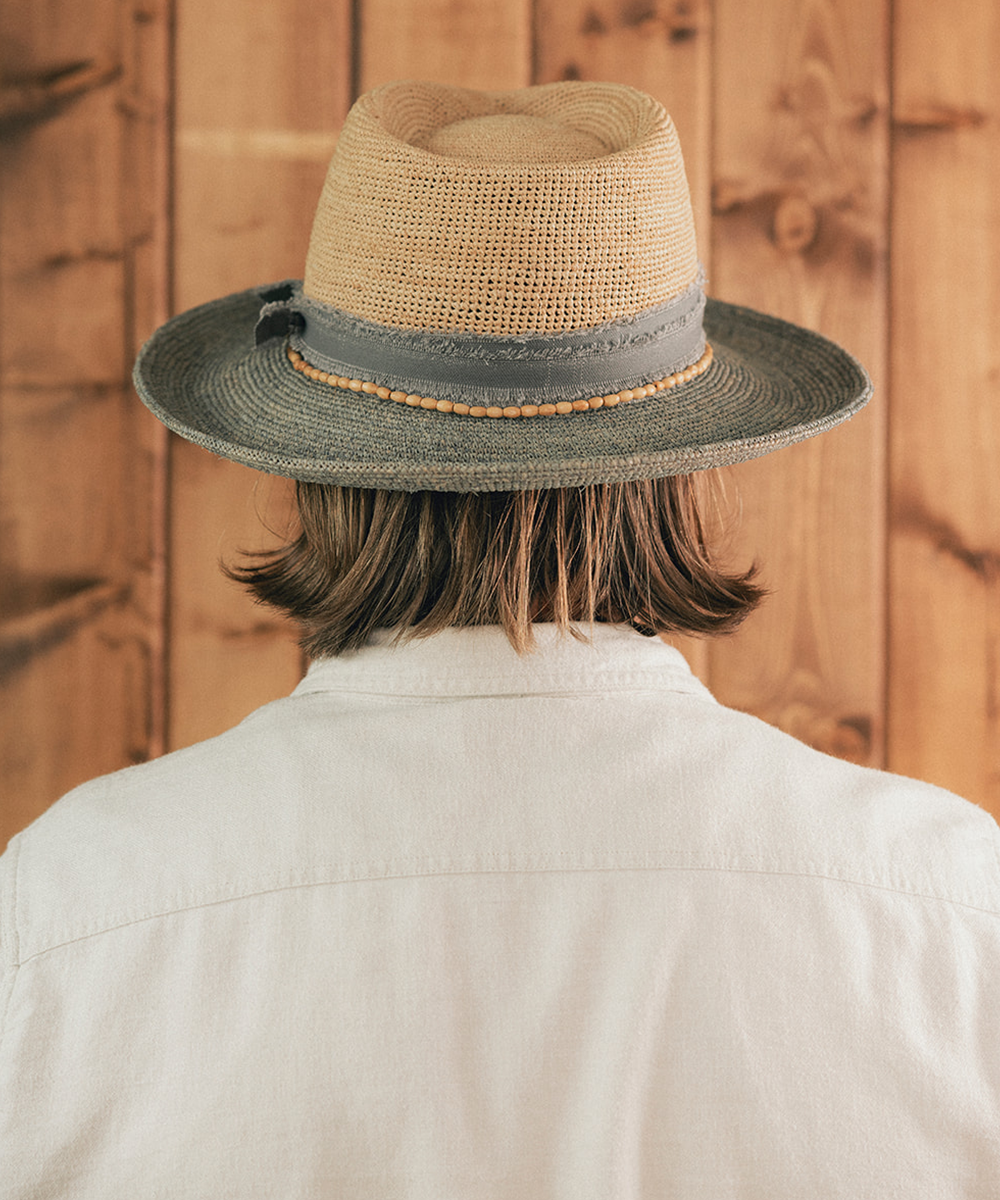 Man wearing a straw hat with a wooden background #color_Natural - Grey Blue