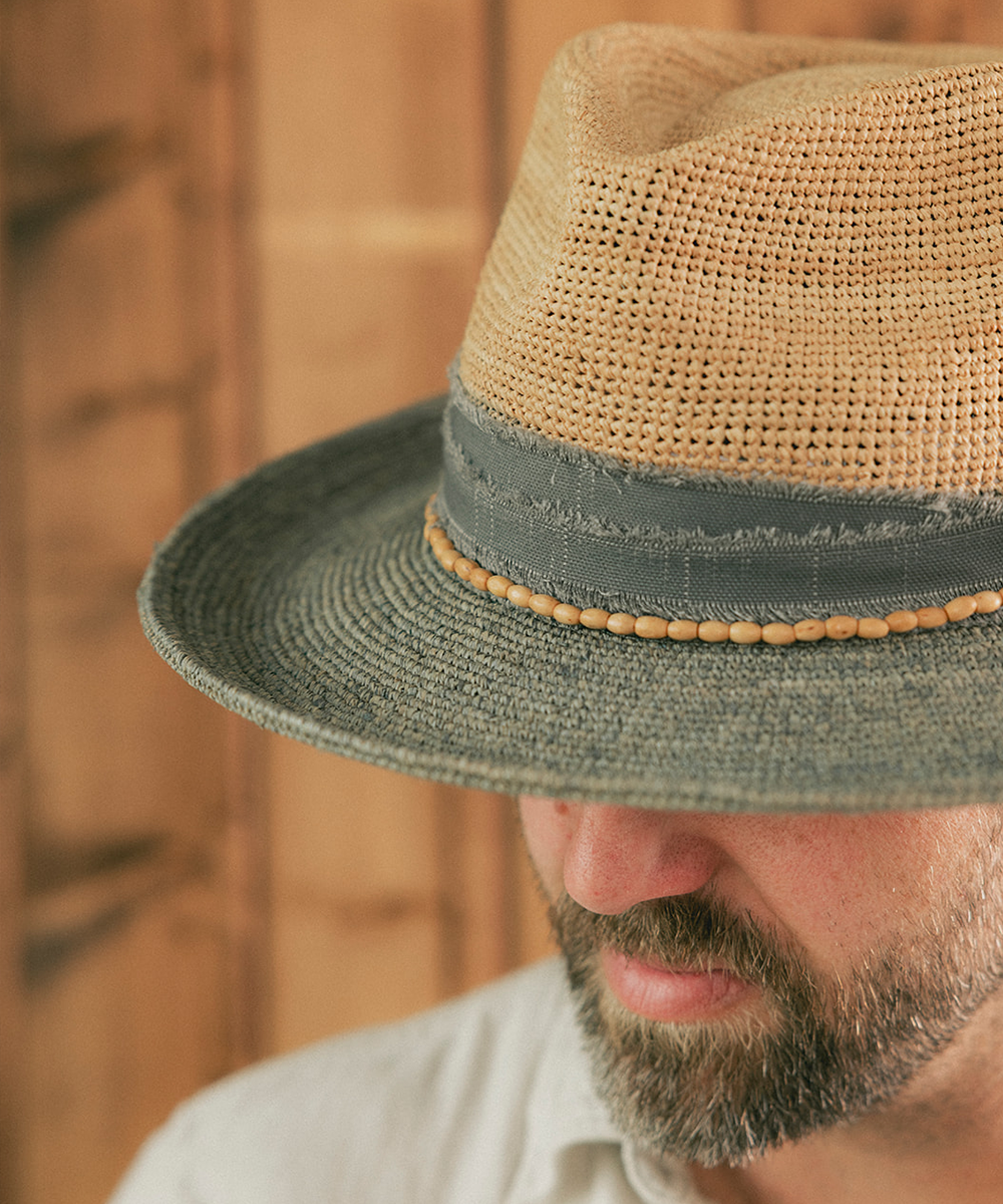 Man wearing a straw hat with a wooden background #color_Natural - Grey Blue