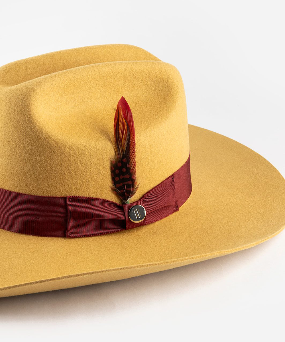 Yellow cowboy hat with a red band and feather on a white background #color_mustard maroon